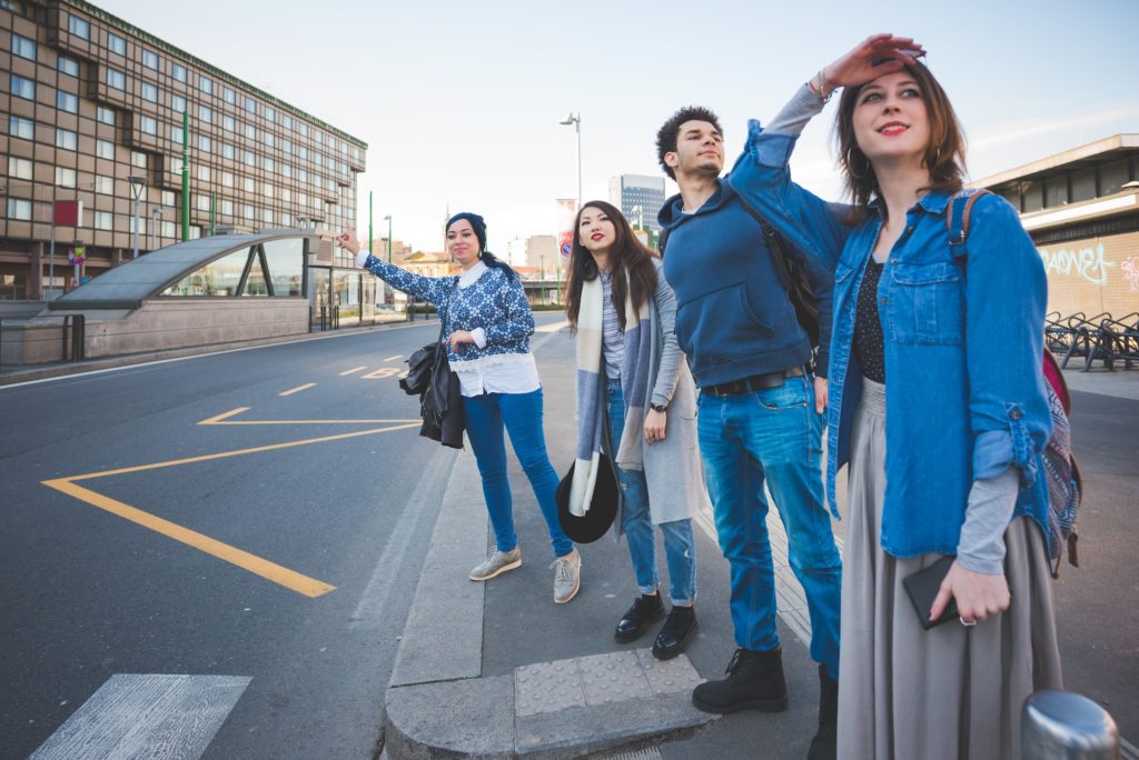 group of multiracial people waiting taxi in the street